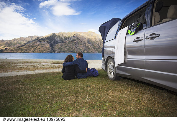 'A couple sits outside their camper van at Kidds Bush campsite at Lake Hawea; Hunter Valley  Otago  New Zealand'