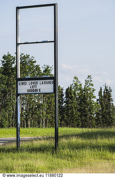 'A old retail sign along the road with a message showing that they have left the premises; Alberta  Canada'