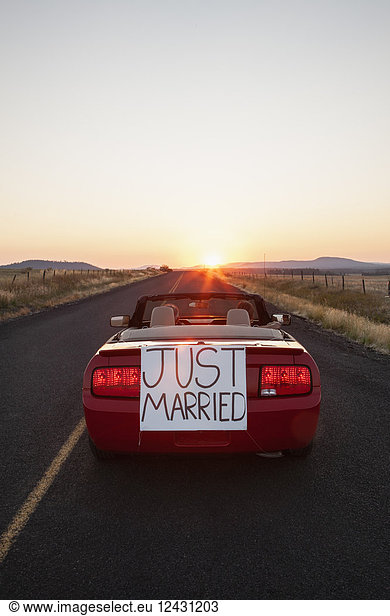'A senior couple ''just married'' riding in a convertible sports car in eastern Washington State  USA.'