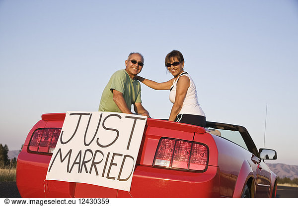 'A senior couple ''just married'' sitting in a convertible sports car in eastern Washington State  USA.'