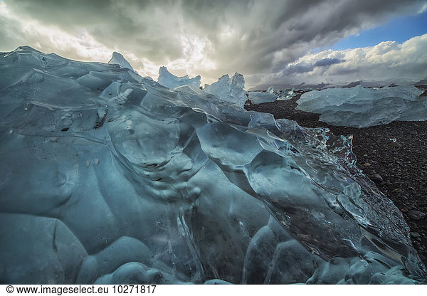 'Along the south shore of Iceland  large chunks of ice litter the beach after being washed out to sea from the Jokulsarlon lagoon; Iceland'