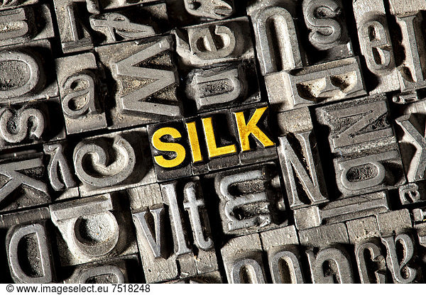 'Alte Bleilettern bilden das englische Wort ''SILK'''