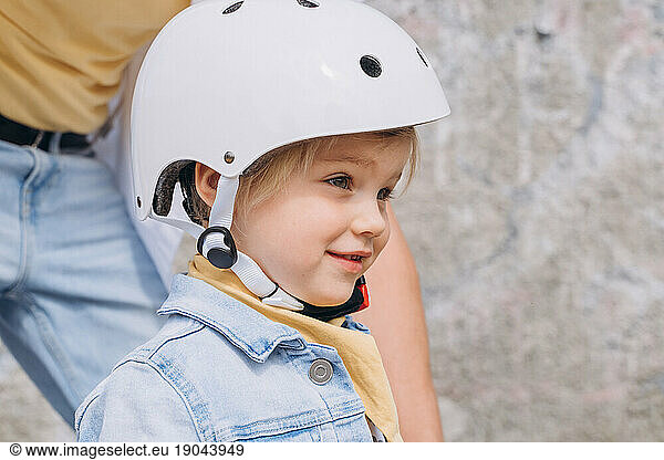 Ð¡aucasian girl preschooler in white helmet riding balance bike