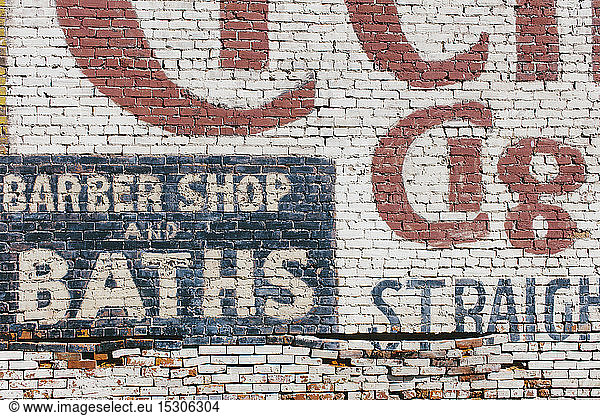 'Barber Shop & Baths' sign painted on old brick wall