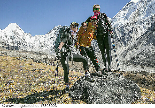 2 Bergsteigerinnen posieren mit ihrem Bergsteiger-Sherpa und einem Freund in der Nähe des Everest