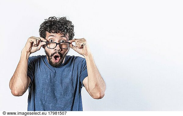 Überrascht Brille Mann hält seine Brille  Emotive jungen kaukasischen Mann starrt durch große Brille