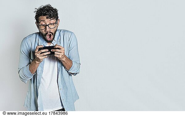 Überrascht Menschen beobachten eine Werbung auf ihrem Handy. Erstaunt Mann hält Handy horizontal auf isolierten Hintergrund  Person keuchend und spielen Spiele auf seinem Handy