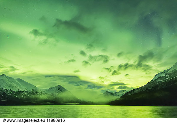 'Bright green Aurora Borealis dances over Upper Trail Lake  the Kenai Mountains in the background  Moose Pass  Kenai Peninsula  South-central Alaska; Alaska  United States of America'