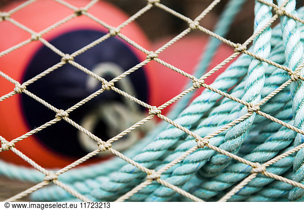 'Close-Up Of Bouys And Line Through The Mesh Of A Commercial Crab Fishing Pot Stored In The Port Of King Cove  Alaska Peninsula; Southwest Alaska  United States Of America'