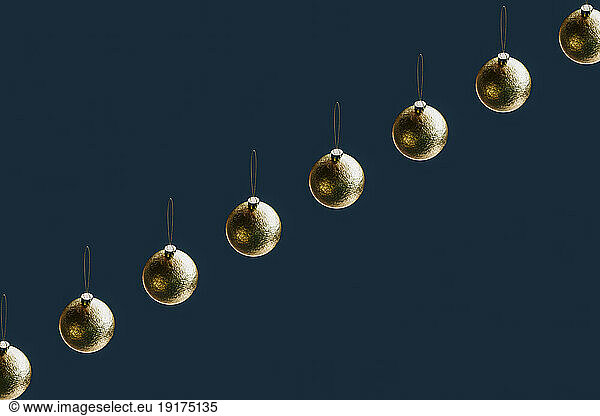 3D render of row of gold-colored Christmas ornaments