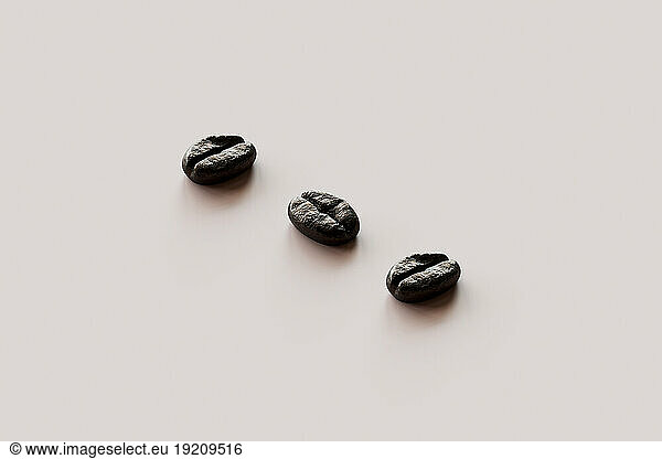 3D render of three roasted coffee beans lying against white background