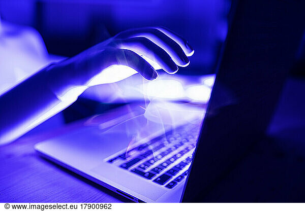 3D rendering of robot hand with laptop at table