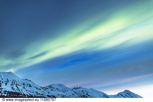 'Green Aurora Borealis dances over partly cloudy skies above the Kenai Mountains  Moose Pass  Kenai Peninsula  South-central Alaska; Alaska  United States of America'
