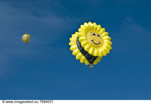 'Hot air balloon in the shape of a ''laughing'' sun or sunflower against a blue sky  12th balloon festival of Tegernsee  Montgolfiade  Bad Wiessee  Tegernsee  Bavaria  Germany  Europe'