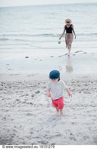 2 Jahre alter Junge mit seiner Mutter am Strand.