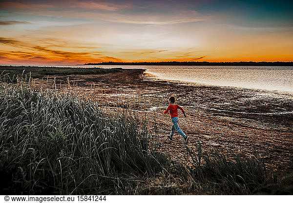 7 Jahre alter Junge rennt bei Sonnenaufgang  um Muscheln zu finden