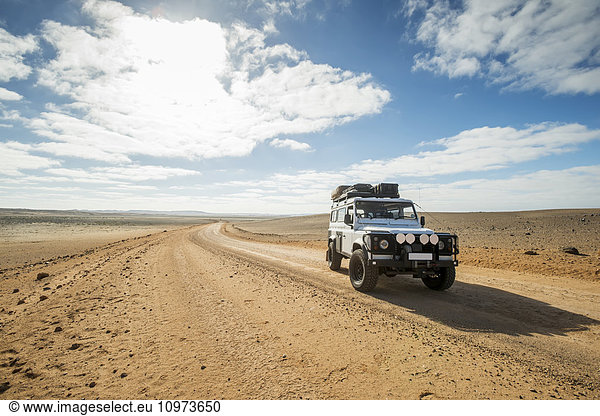 'Land Rover Defender 110 driving on the road; Cape Cross  Namibia'