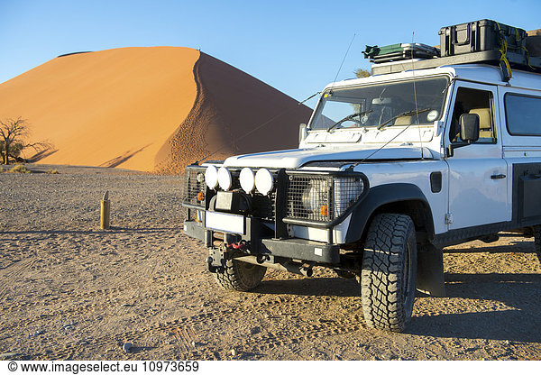'Land Rover Defender 110 parked in the desert with dunes in the distance; Sossusvlei  Namibia'