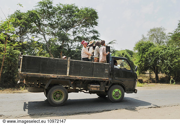 'Local workers riding in the back of the truck; Bagan  Myanmar'