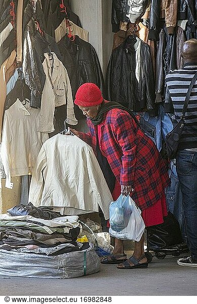 Ältere afrikanische Frau kauft Kleidung auf dem Markt am Soweto-Taxistand  Südafrika