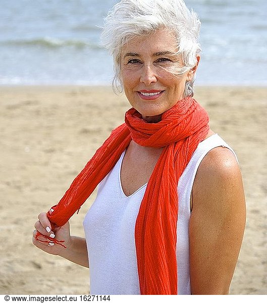 Ältere Frau im weißen Anzug genießt einen Nachmittag am Strand von Islantilla  Huelva