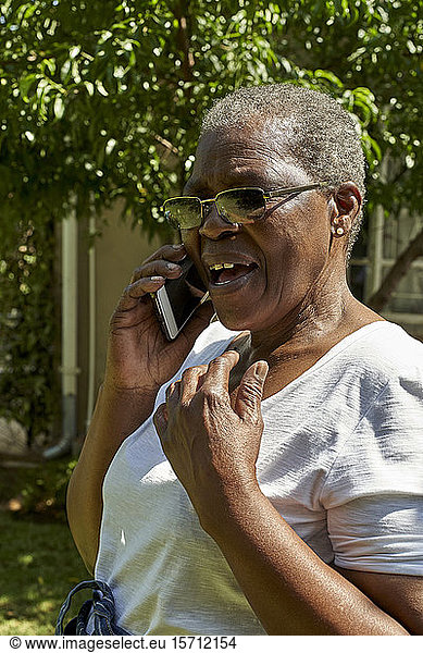 Ältere Frau telefoniert im Freien