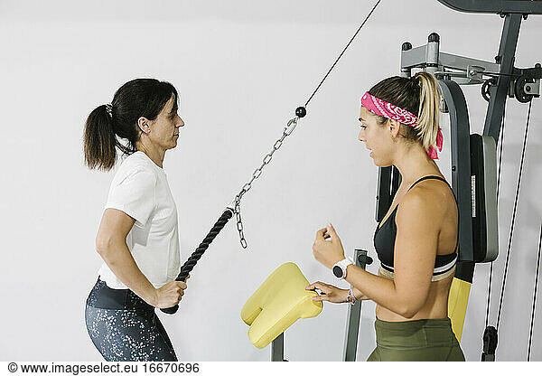 Ältere Frau trainiert mit ihrem Personal Trainer im Fitnessstudio