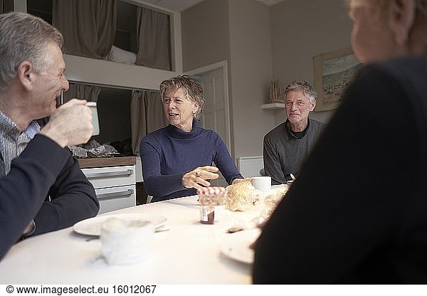 Ältere Freunde beim gemeinsamen Frühstück in der Ferienwohnung