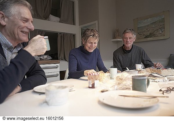 Ältere Freunde beim gemeinsamen Frühstück in der Ferienwohnung