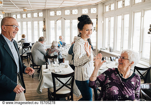 Ältere Freunde geben High-Five im Restaurant