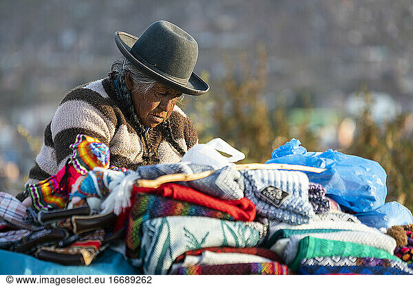 Ältere Verkäuferin verkauft Pullover  Cusco  Peru