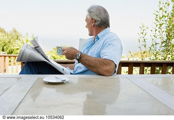 Älterer erwachsener Mann beim Lesen der Zeitung