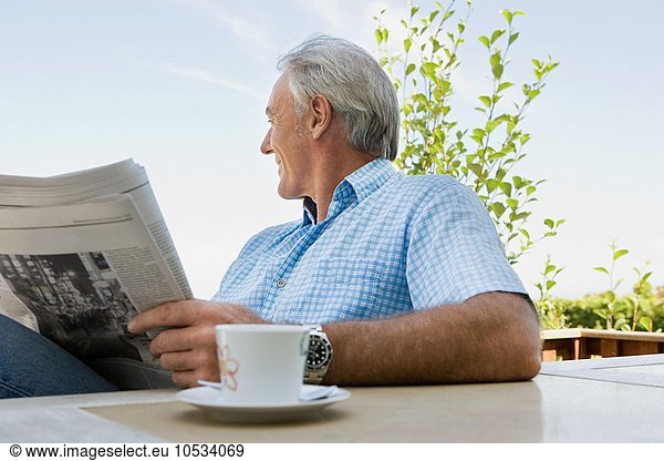 Älterer erwachsener Mann beim Lesen einer Zeitung