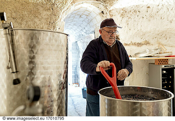 Älterer männlicher Winzer bei der Weinvorbereitung in der Weinkellerei