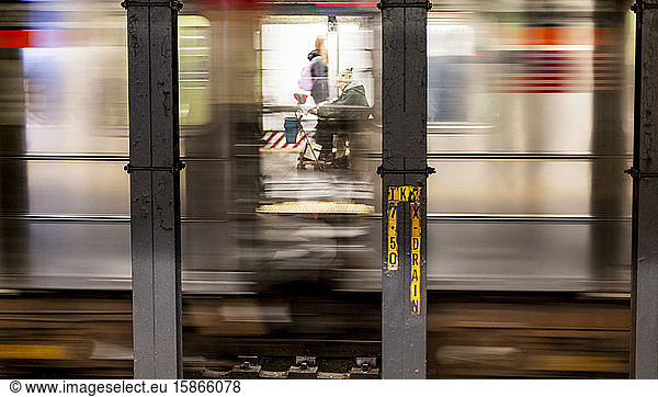 Älterer Mann auf einem Motorroller  gesehen durch ein U-Bahn-Fenster mit der Unschärfe durch die Geschwindigkeit der U-Bahn  Manhattan; New York City  New York  USA