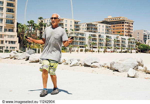 Älterer Mann  Hüpfen am Strand  Long Beach  Kalifornien  USA