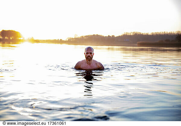 Älterer Mann im Wasser am Morgen
