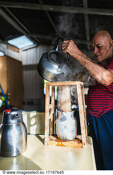 Älterer Mann kocht Kaffee auf traditionelle Art