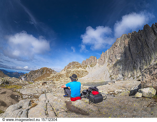 Älterer Mann macht eine Pause vom Wandern in der Berglandschaft  Fleimser Alpen  Trentino  Italien