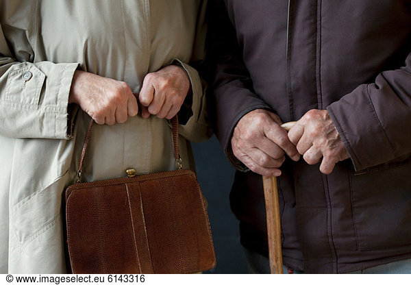 Älterer Mann mit Gehstock  ältere Frau mit Handtasche