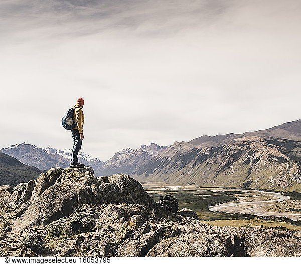 Älterer Mann mit Rucksack auf einem Felsen stehend gegen den Himmel  Patagonien  Argentinien