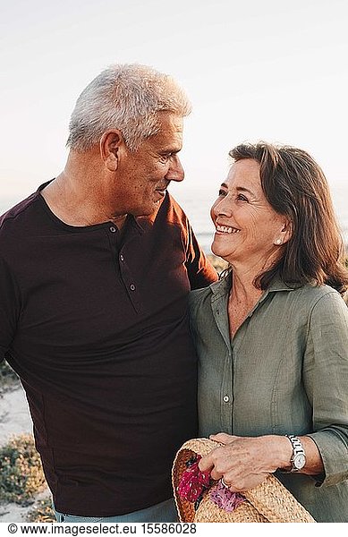 Älteres Ehepaar blickt sich am Strand in die Augen