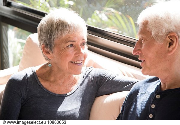 Älteres Ehepaar  entspannend  von Angesicht zu Angesicht sitzend