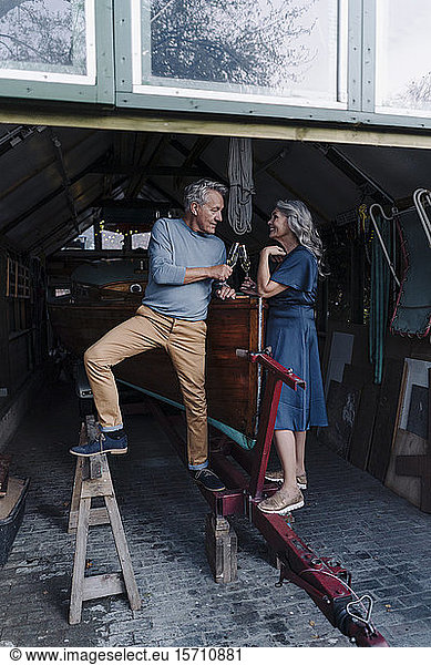Älteres Ehepaar in einem Bootshaus  Champagnergläser klirrend