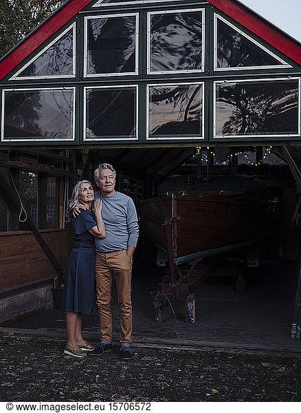 Älteres Ehepaar steht vor dem Bootshaus