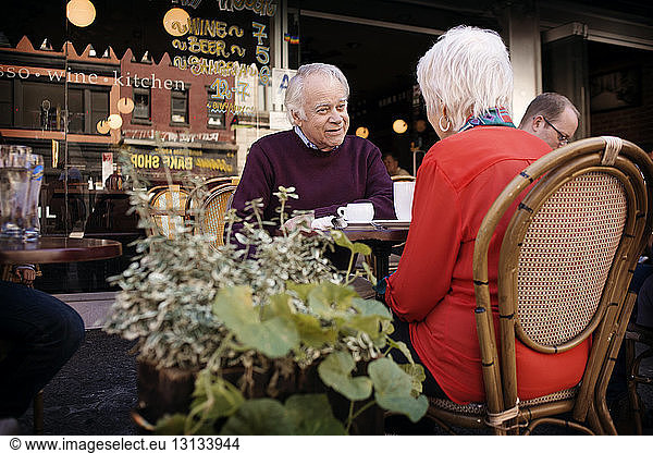 Älteres Ehepaar unterhält sich im Straßencafé