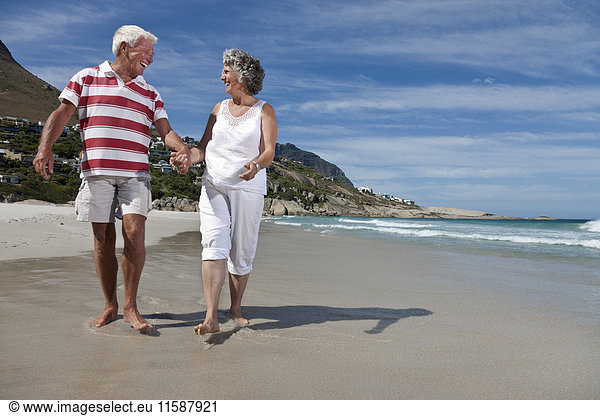 Älteres Paar beim gemeinsamen Strandspaziergang