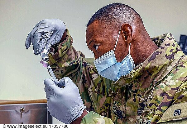 210119-N-ZU710-0137 CHINHAE  Republik Korea (19. Januar 2021) Sgt. Adrian Yelder füllt eine Spritze mit einer Dosis des Impfstoffs COVID-19 in der Navy Branch Health Clinic Chinhae. Matrosen der Branch Health Clinic Chinhae und Soldaten des 549th Hospital Center  65th Medical Brigade  verabreichten COVID-19-Impfstoffe auf völlig freiwilliger Basis an Personal  das durch DoD-Verteilungsrichtlinien identifiziert wurde.
