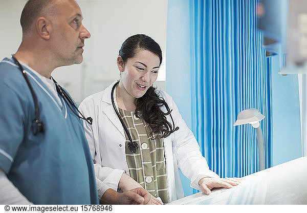 Ärzte besprechen Papierkram im Krankenhauszimmer