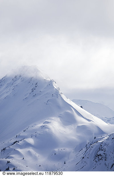 'Snow covered Kenai Mountain peaks under clouds  Kachemak Bay State Park; Alaska  United States of America'